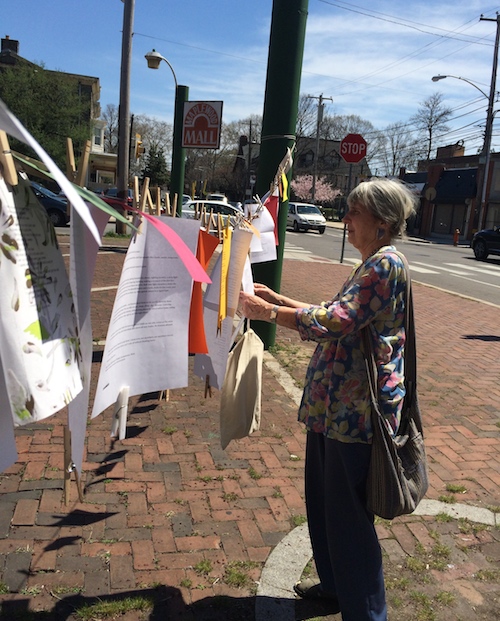 Paula Paul hangs poems on the line for Philly Poetry Day in Gtown