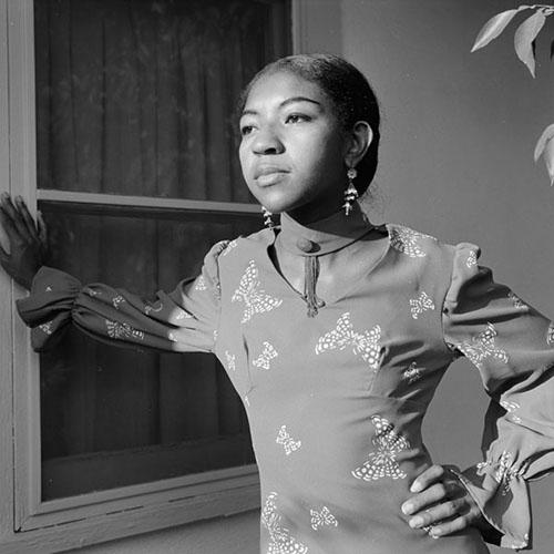 Poet Ai looks into the distance with one hand on a wall at the University of Arizona Poetry Center for the Fall 1972 Reading and Lecture Series.