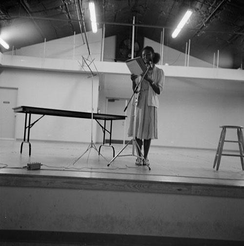 Poet Harryette Mullen reads on stage at the 1981 Lone Star Poetry Festival in Austin, Texas. 