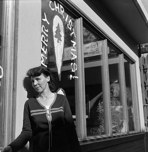 Poet Ruth Stone poses under a shop window during her visit for the University of Arizona Poetry Center's Fall 1965 Reading and Lecture Series. 