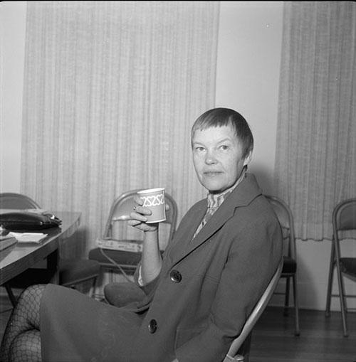 Poet and playwright May Swenson poses sitting with a cup in hand for the University of Arizona Poetry Center's Spring 1965 Reading and Lecture Series. 